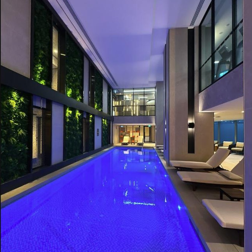 Clean glass windows beside an indoor lap pool at night