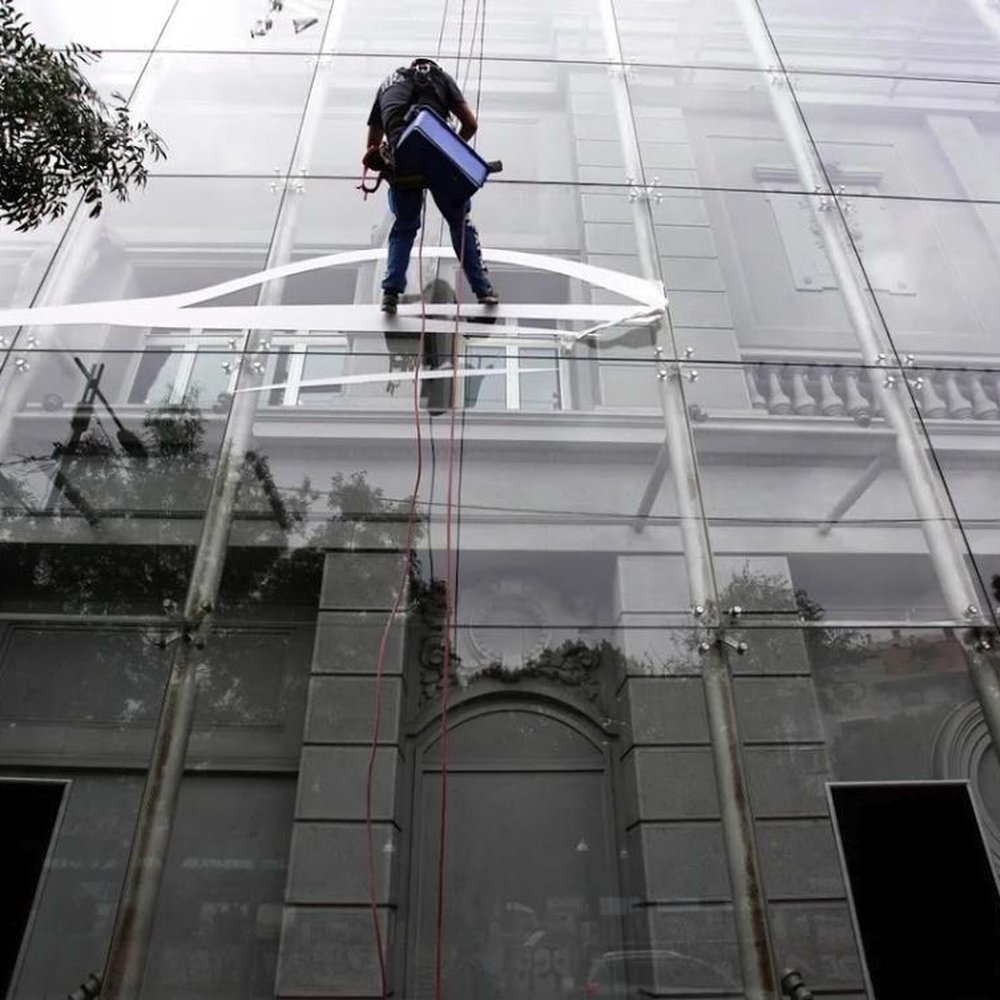 Rope access technician cleaning a multi-storey heritage building facade